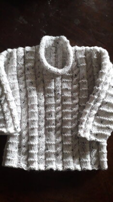 Roll neck cabled  baby sweater with matching hat.
