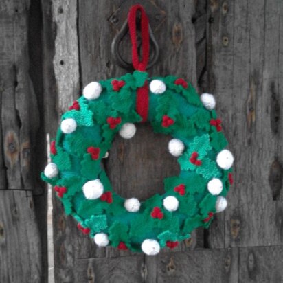 Knitted Christmas wreath with holly leaves, berries and snowballs
