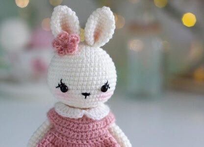 Little bunny toy in light pink dress with the flower on the ear