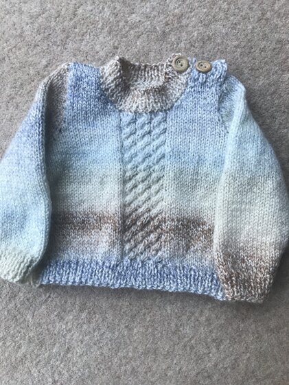 Baby/toddler cable front jumper with button fastening.