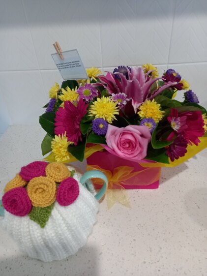 Bright tea cosy and flowers