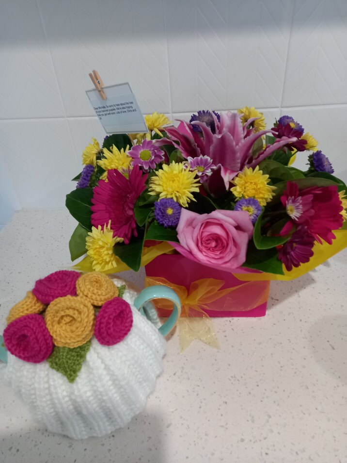 Bright tea cosy and flowers